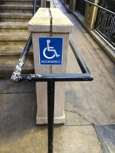 photo of ramp and blue sign with wheelchair accessibility symbol